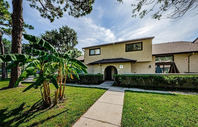 view of front of house with a front lawn and stucco siding