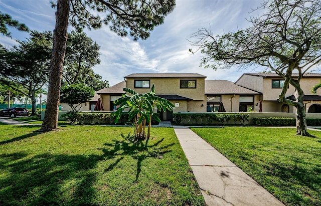 view of front of home with a front yard and stucco siding