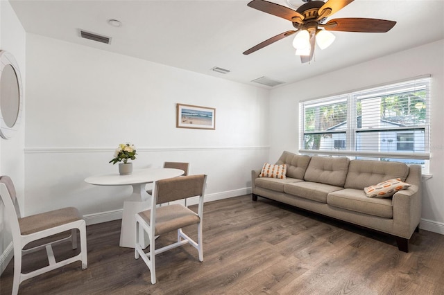 living room featuring ceiling fan and dark wood-type flooring