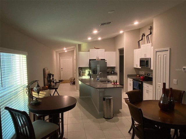 kitchen featuring sink, light tile patterned flooring, vaulted ceiling, white cabinets, and appliances with stainless steel finishes