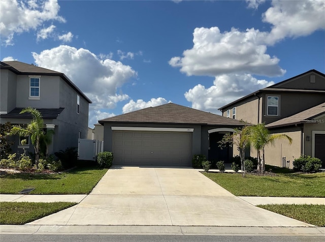 view of front of house with a front yard, concrete driveway, an attached garage, and stucco siding