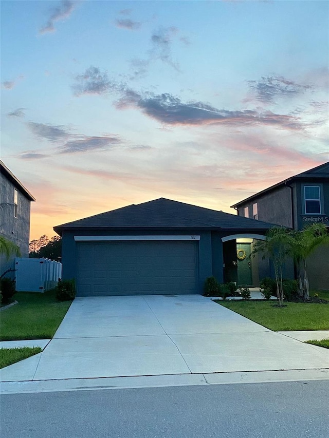 view of front of home with a garage, driveway, and a front lawn