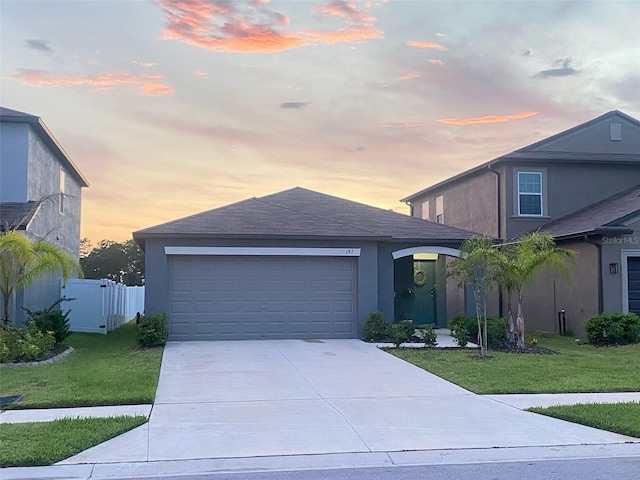 view of front facade with a garage and a lawn