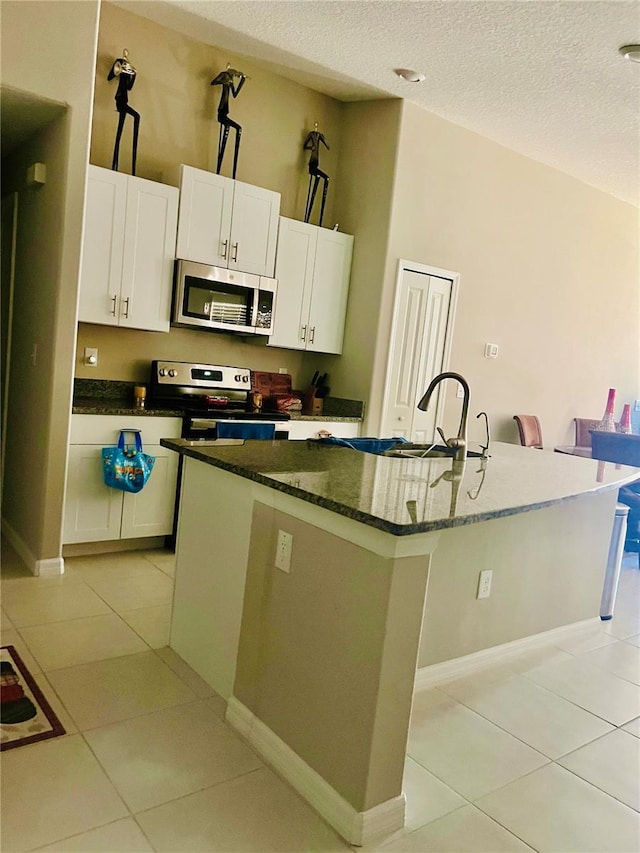 kitchen featuring appliances with stainless steel finishes, a center island with sink, white cabinetry, and sink