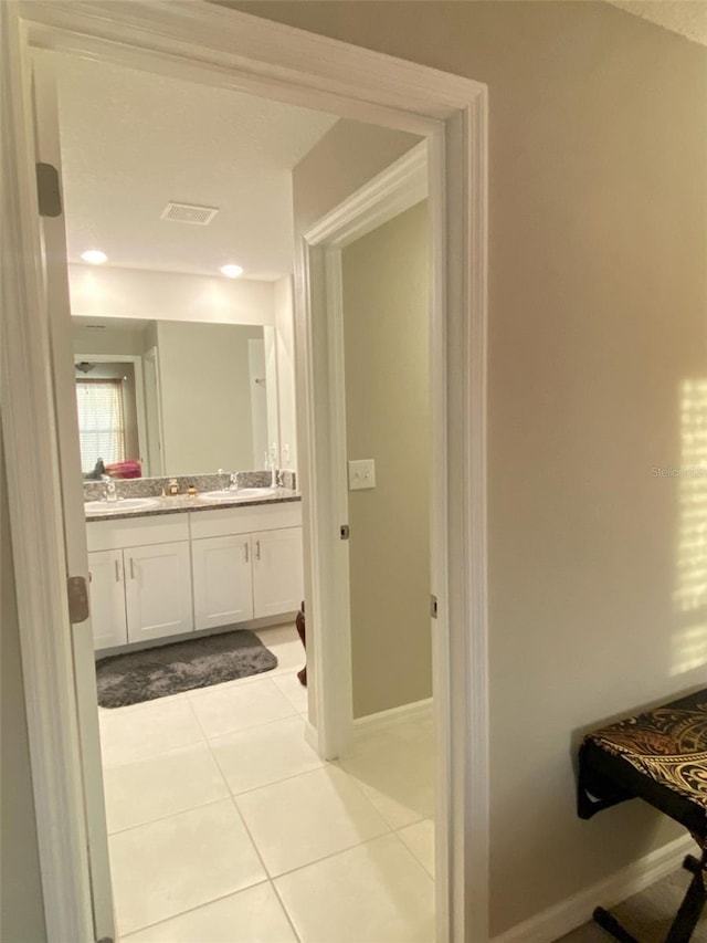 bathroom with baseboards, vanity, visible vents, and tile patterned floors