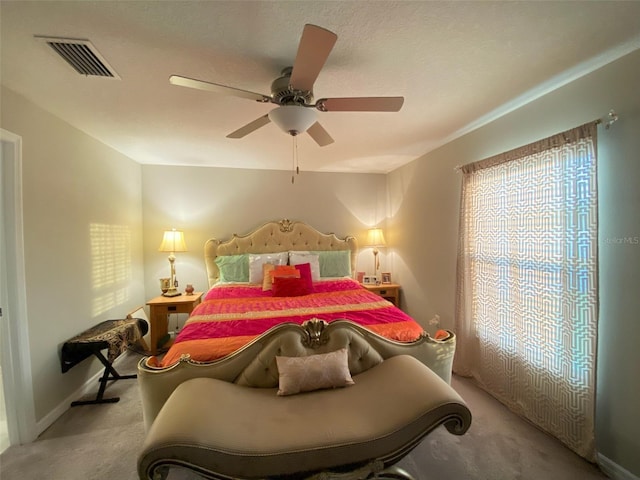 bedroom with ceiling fan, carpet flooring, visible vents, and baseboards