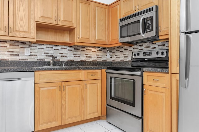 kitchen with backsplash, appliances with stainless steel finishes, sink, dark stone counters, and light tile patterned flooring