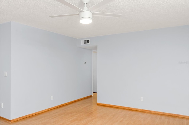 empty room with a textured ceiling, light hardwood / wood-style flooring, and ceiling fan