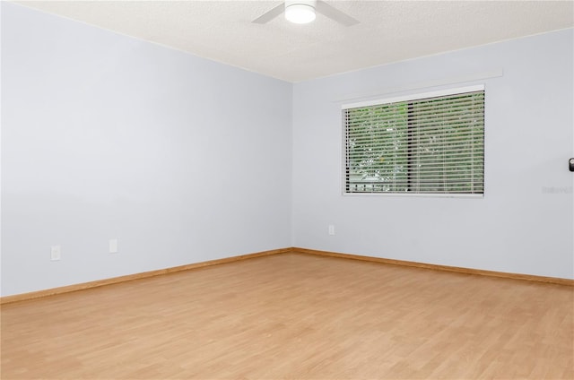 empty room featuring ceiling fan, light hardwood / wood-style floors, and a textured ceiling