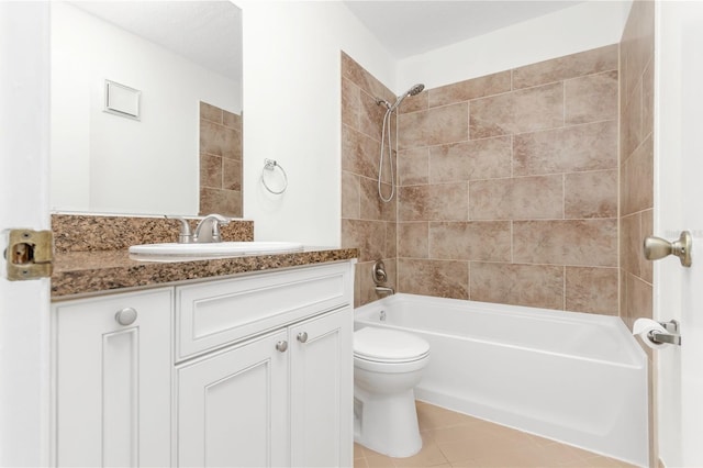 full bathroom with tiled shower / bath, vanity, toilet, and tile patterned floors