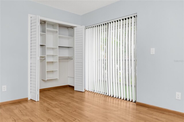 unfurnished bedroom featuring light wood-type flooring and a closet