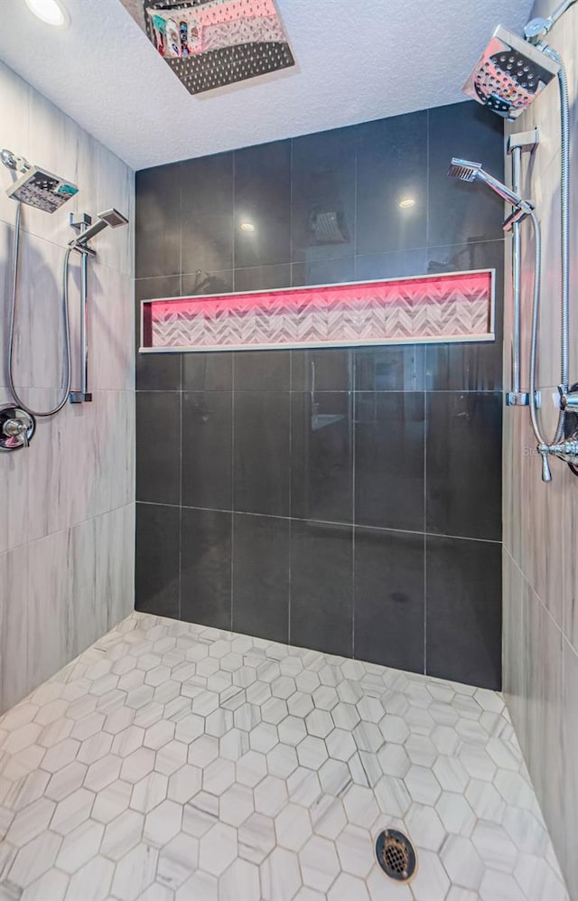 bathroom featuring a textured ceiling and tiled shower