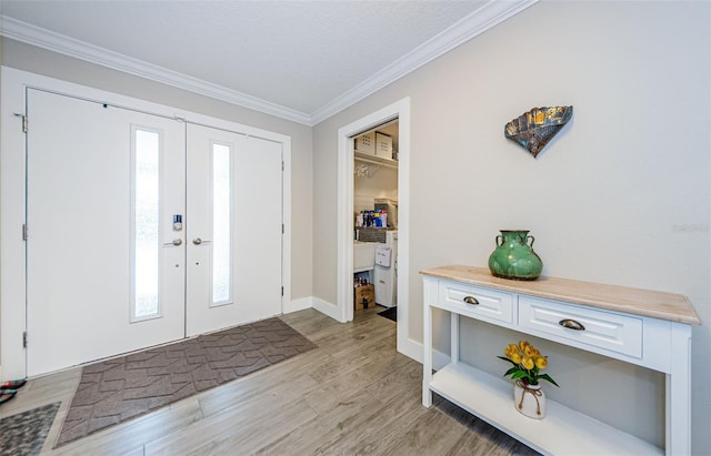 foyer entrance with ornamental molding, french doors, a healthy amount of sunlight, and light hardwood / wood-style floors