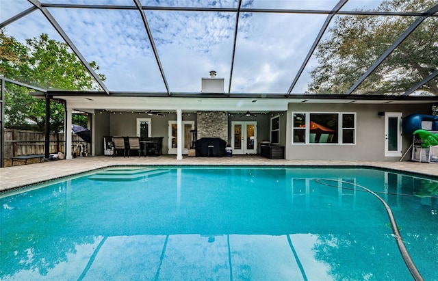 view of swimming pool featuring glass enclosure, french doors, area for grilling, ceiling fan, and a patio