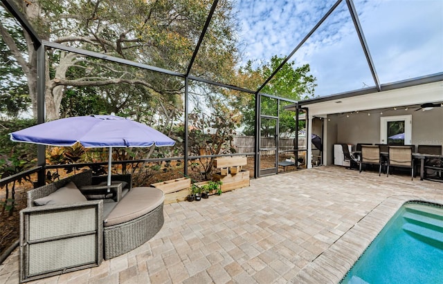 view of patio / terrace featuring glass enclosure, a fenced in pool, and ceiling fan