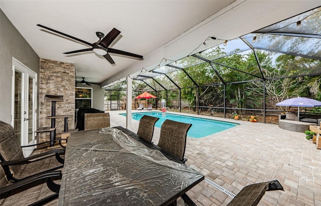 view of pool with a lanai, a patio, and ceiling fan