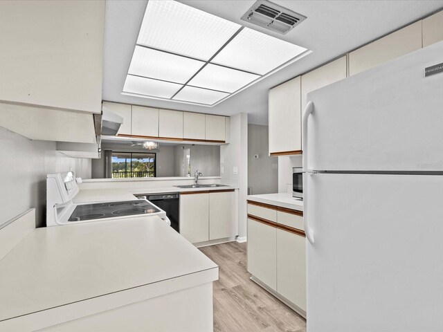 kitchen with kitchen peninsula, light wood-type flooring, sink, and white appliances