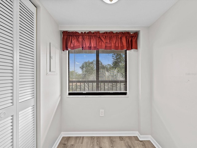 spare room featuring baseboards and wood finished floors