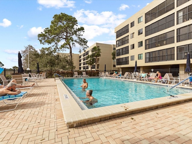 community pool featuring fence and a patio