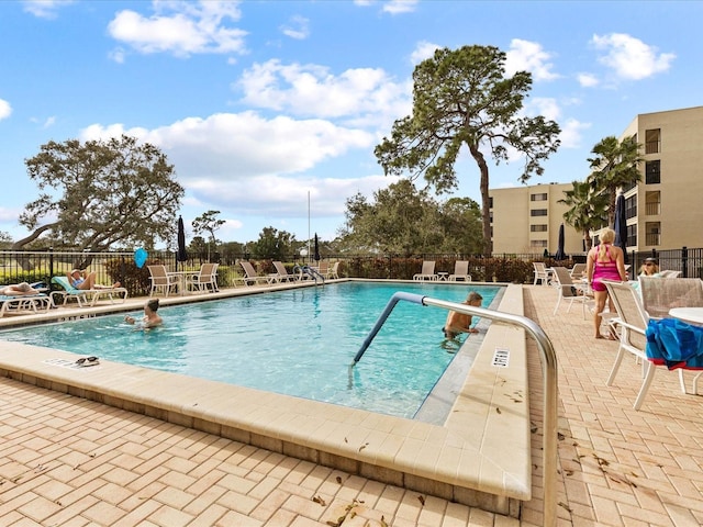 community pool featuring a patio area and fence