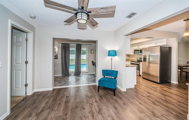 sitting room with wood-type flooring, a textured ceiling, and ceiling fan