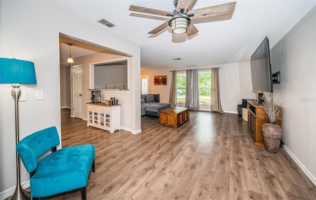 interior space featuring wood-type flooring, a textured ceiling, and ceiling fan