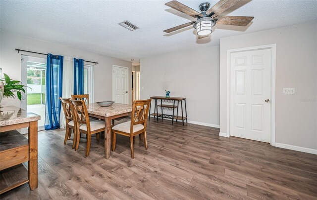 dining room with wood-type flooring, a textured ceiling, and ceiling fan