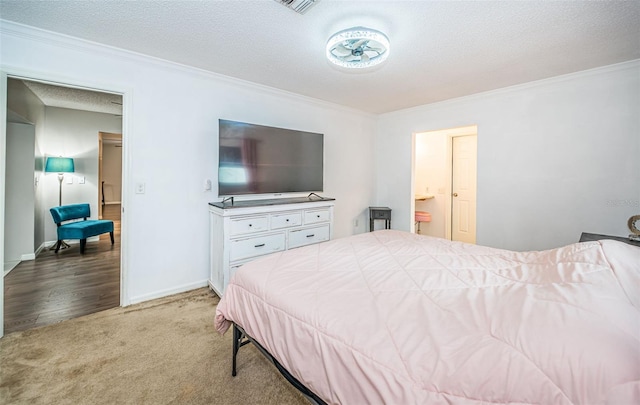 bedroom featuring connected bathroom, ornamental molding, and light carpet