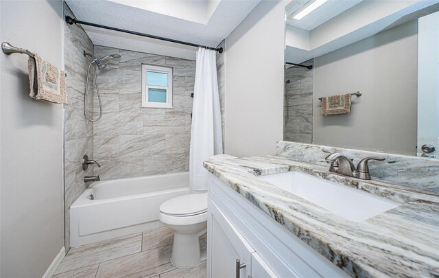 full bathroom featuring tile patterned flooring, toilet, shower / bath combination with curtain, vanity, and a textured ceiling