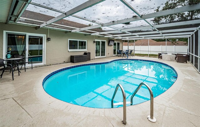 view of swimming pool with glass enclosure and a patio area