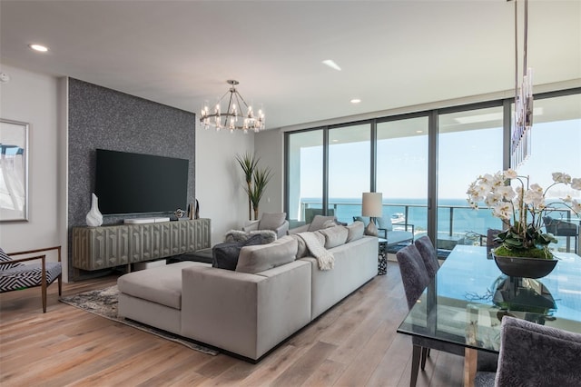 living room with light wood-type flooring, floor to ceiling windows, and a chandelier