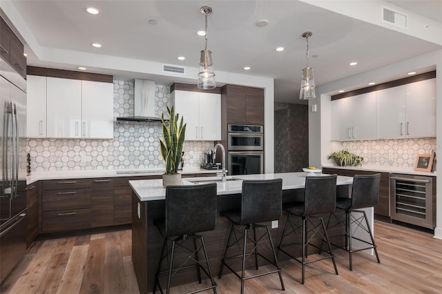 kitchen featuring an island with sink, tasteful backsplash, and light hardwood / wood-style flooring