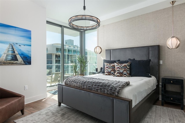 bedroom featuring expansive windows and hardwood / wood-style flooring