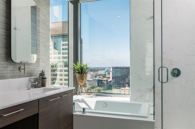 bathroom featuring vanity and independent shower and bath