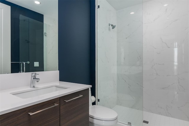 bathroom featuring vanity, toilet, and tiled shower