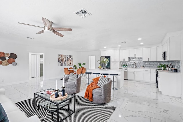 living room featuring ceiling fan and sink