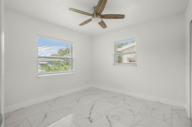 empty room featuring a textured ceiling, plenty of natural light, and ceiling fan