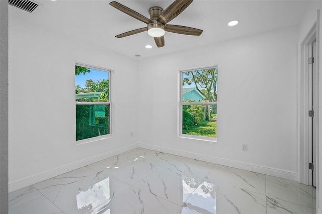 empty room featuring a wealth of natural light and ceiling fan