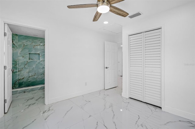 unfurnished bedroom featuring ceiling fan, ensuite bath, and a closet