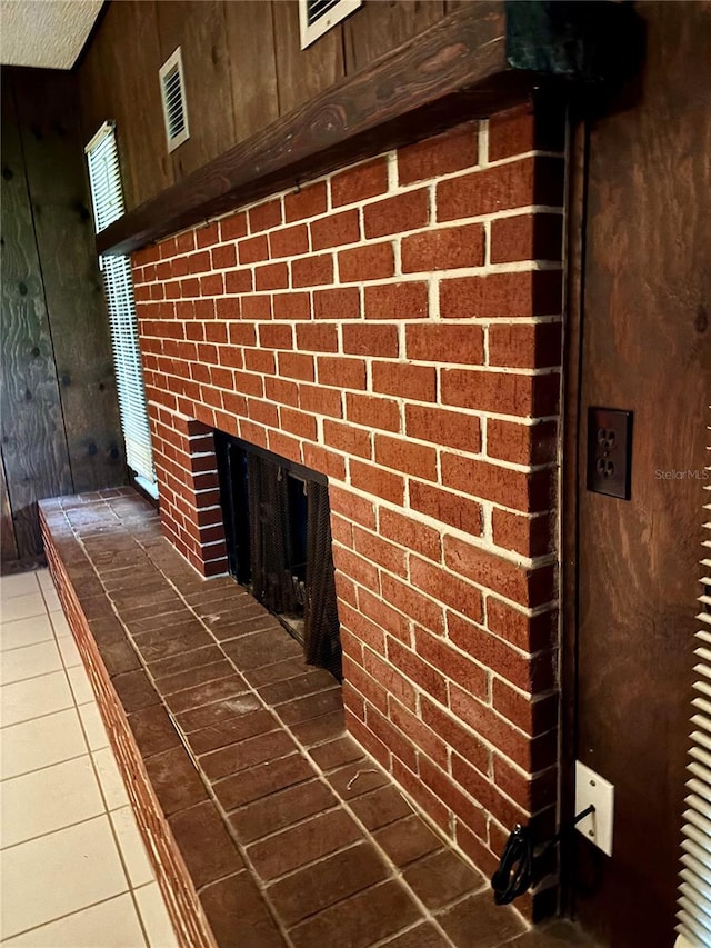 interior details with tile patterned flooring and wooden walls