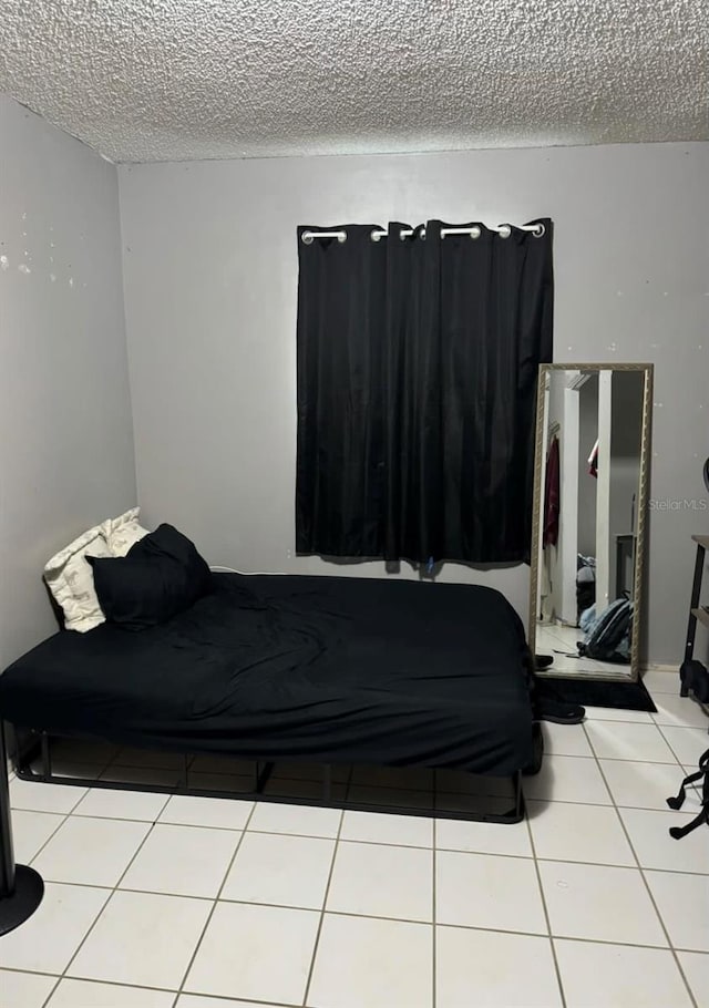 tiled bedroom featuring a textured ceiling