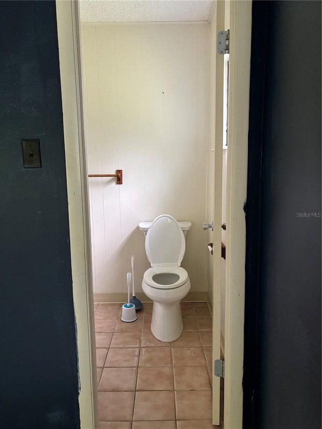 bathroom featuring a textured ceiling, toilet, and tile patterned flooring