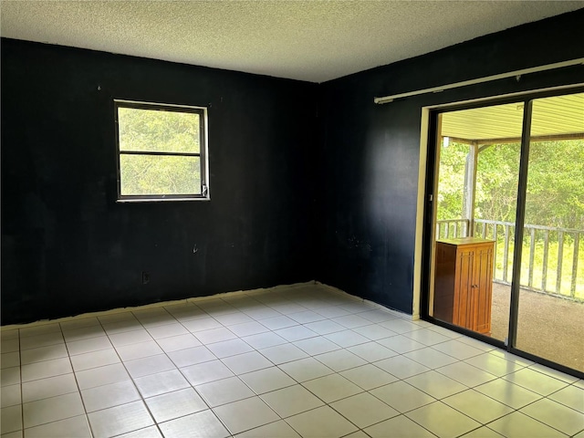 tiled spare room featuring a textured ceiling