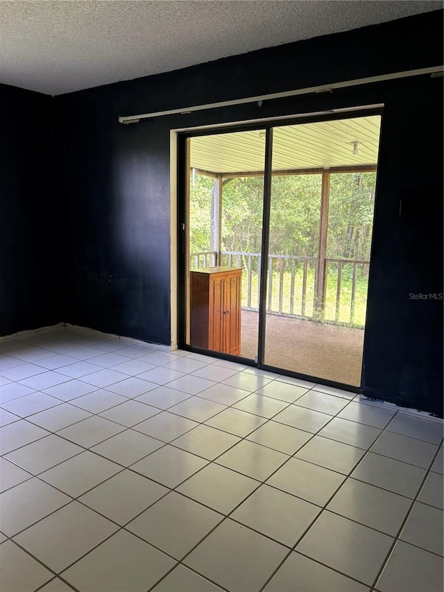 tiled empty room with a textured ceiling