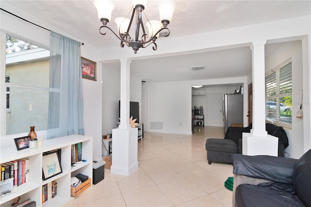 living room with light tile patterned flooring and an inviting chandelier