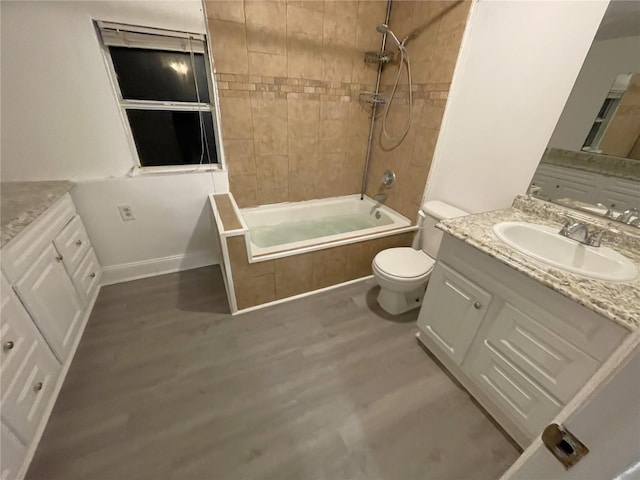 full bathroom with vanity, tiled shower / bath combo, toilet, and hardwood / wood-style flooring