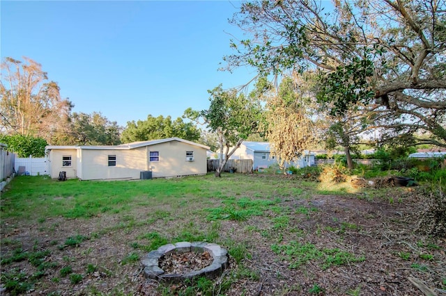 view of yard with an outdoor fire pit and central air condition unit