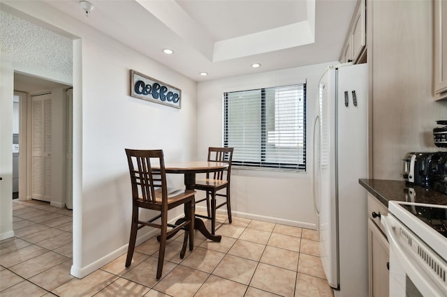 14950 Gulf Blvd Unit 404, Madeira Beach, FL 33708 - dining space featuring light tile patterned floors, baseboards, recessed lighting, and a tray ceiling