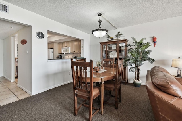 14950 Gulf Blvd Unit 404, Madeira Beach, FL 33708 - dining room featuring light colored carpet, a textured ceiling, and baseboards