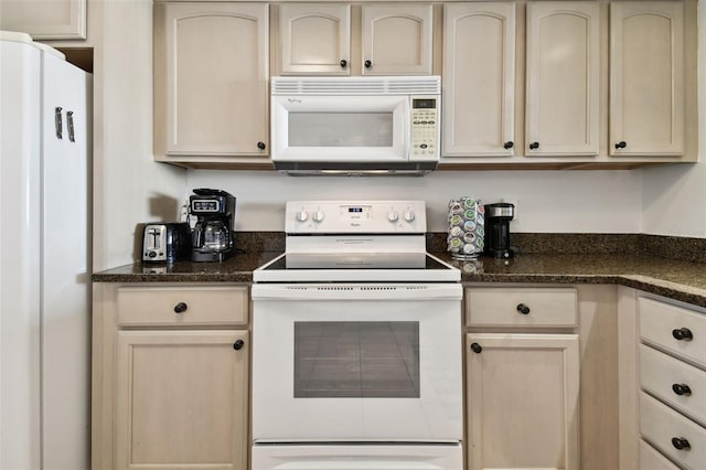 14950 Gulf Blvd Unit 404, Madeira Beach, FL 33708 - kitchen with white appliances, dark stone countertops, and cream cabinetry
